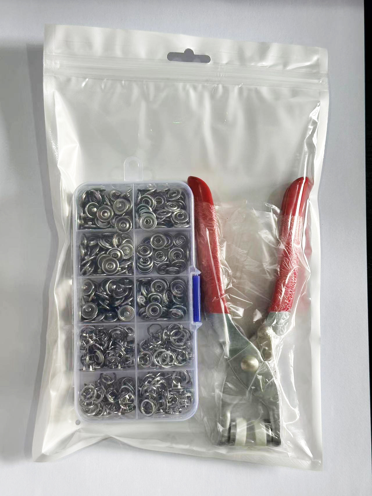 Iron pliers + 100 silver buttons in a box